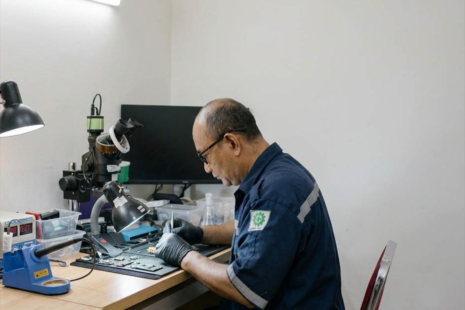Teknisi YES Camera bekerja di meja solder dengan mikroskop